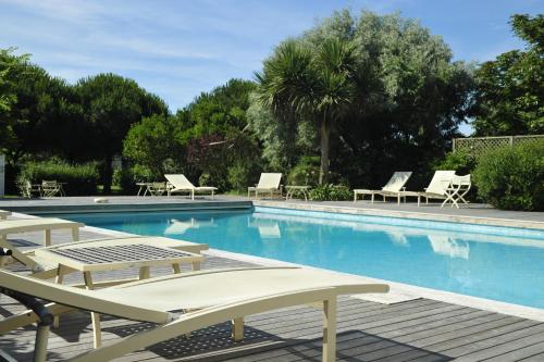 - une piscine bordée de chaises longues et de chaises longues dans l'établissement Anne de Bretagne, à La Plaine-sur-Mer