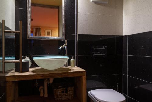 a bathroom with a sink and a toilet and a mirror at Chalet Schuler in Zermatt