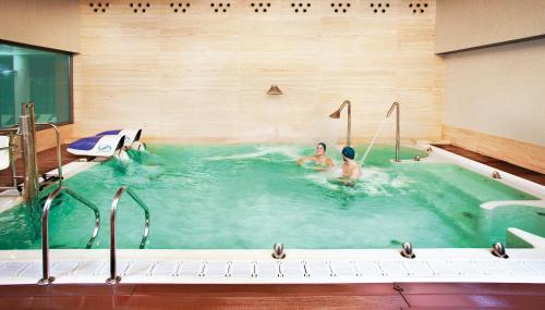 two people are in a swimming pool at Hotel Solverde Spa and Wellness Center in Vila Nova de Gaia