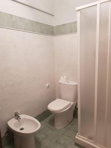 a white bathroom with a toilet and a sink at Appartamento in Complesso Sonia in Santa Teresa di Riva