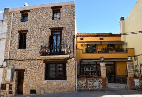 a stone building with a balcony on the side of it at EVA & TRAVEL - El Cor del Montsant in Ulldemolins