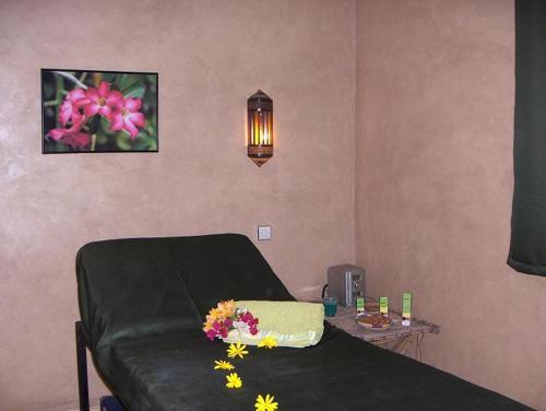 a room with a bed with flowers on it at Le Jardin Des Epices in Taroudant
