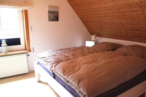 een bed in een slaapkamer met een houten plafond bij Leuchtturm in Fehmarn