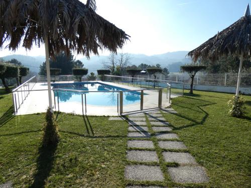 una piscina en un patio con una palmera en Quintinha dos Queiroses en Vila Boa de Quires