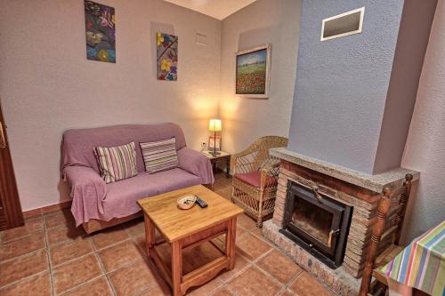 a living room with a couch and a fireplace at Apartamentos Rurales El Solitario in Baños de Montemayor