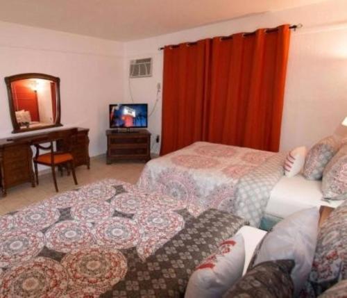 a hotel room with a bed and a television at Gables Inn in Miami