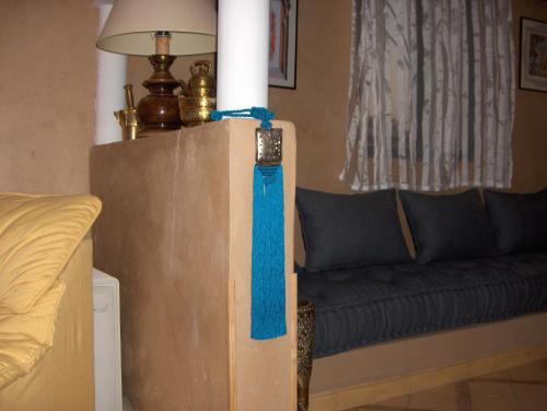 a living room with a couch and a blue ribbon at Le Jardin Des Epices in Taroudant