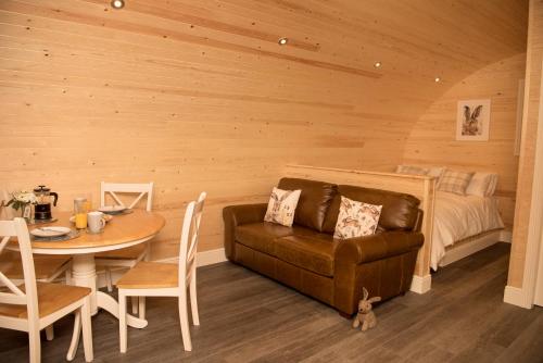a living room with a couch and a table and a bed at Braeside Retreats in Thurso