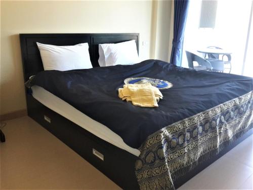 a bed with a blue blanket and a yellow robe on it at The Sea Condominium 267/50 in Sam Roi Yot