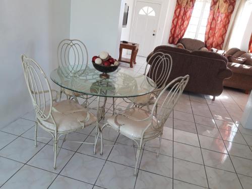 a glass table and chairs in a living room at Personal Touch 1 in Nassau