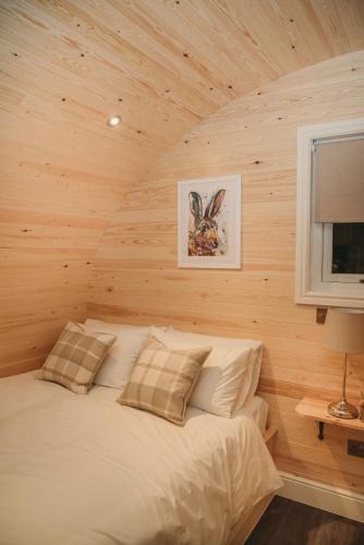 a bedroom with a bed in a log cabin at Braeside Retreats in Thurso