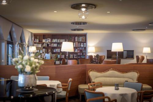 a lobby with tables and chairs and a library at Resort Hof Weissbad in Weissbad
