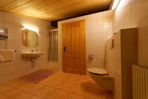 a bathroom with a toilet and a sink and a door at Fleckhof in Neustift im Stubaital