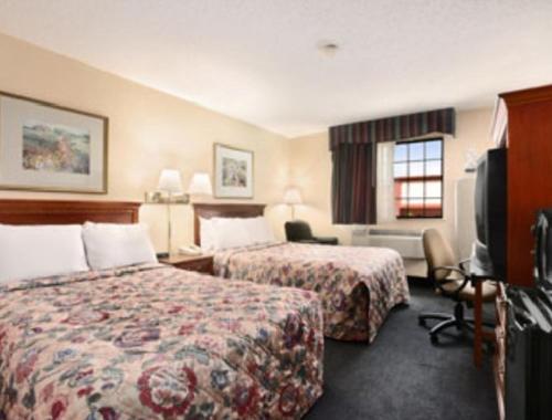 a hotel room with two beds and a television at Days Inn by Wyndham Keene NH in Keene