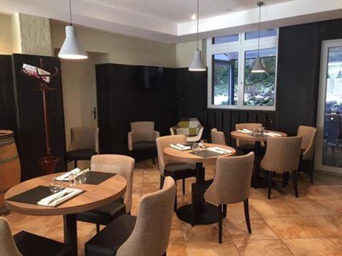 a restaurant with tables and chairs in a room at Hotel Restaurant au Floridor in Thann