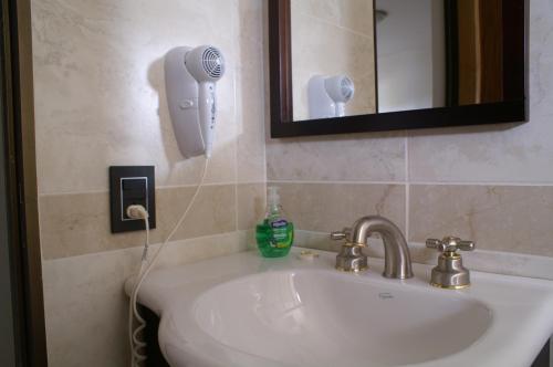lavabo en el baño con secador de pelo en la pared en Departamentos Misiones, en Posadas