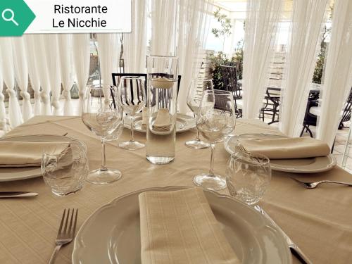 a table with wine glasses and napkins on it at Le Nicchie Guest House in Lucera