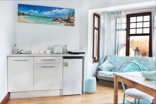 eine Küche und ein Wohnzimmer mit einem Sofa und einem Tisch in der Unterkunft Apartament the Sun in Rewal