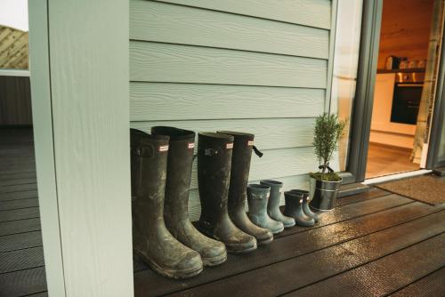 a row of rubber boots on the side of a house at Braeside Retreats in Thurso