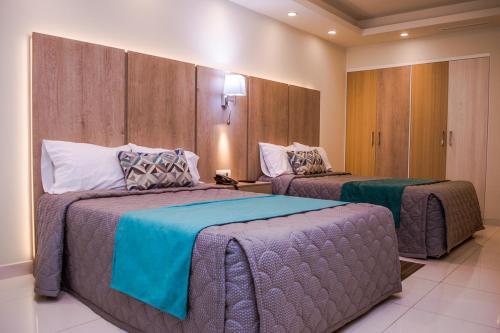 ein Hotelzimmer mit 2 Betten in einem Zimmer in der Unterkunft La Siesta Hotel in Hermosillo
