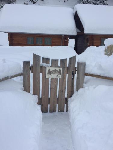 a fence covered in snow next to a house at Alpine Chalet in Santa Caterina Valfurva