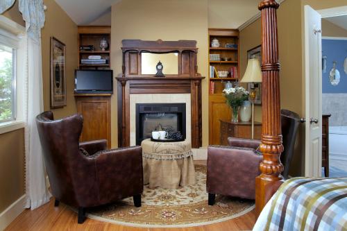a living room with two chairs and a fireplace at Heartstone Inn in Eureka Springs