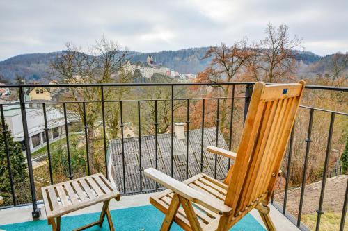 a wooden chair sitting on top of a balcony at Pension Vila Hana in Loket