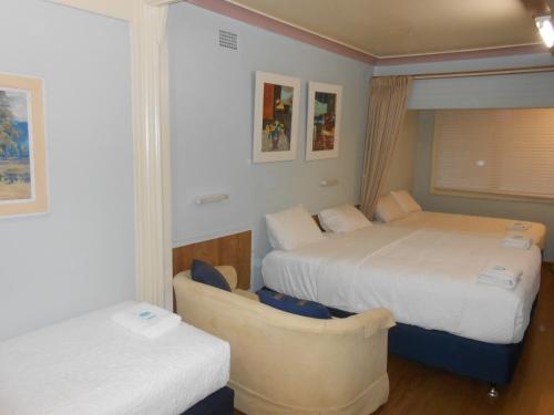 a hotel room with two beds and a couch at Mount View Motel in Bulahdelah