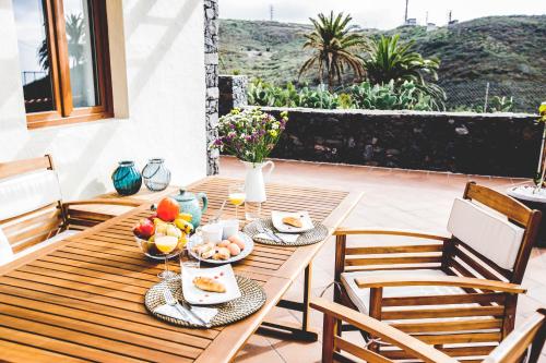 a wooden table with bowls of fruit on a patio at La Casita de Papel in Valle Gran Rey