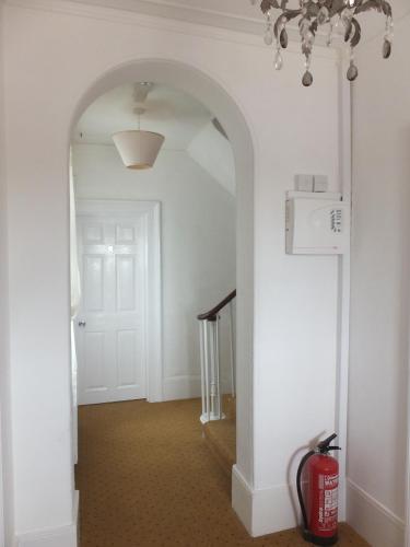 a hallway with an archway with a fire hydrant in it at Jessamine House Hotel in Gravesend