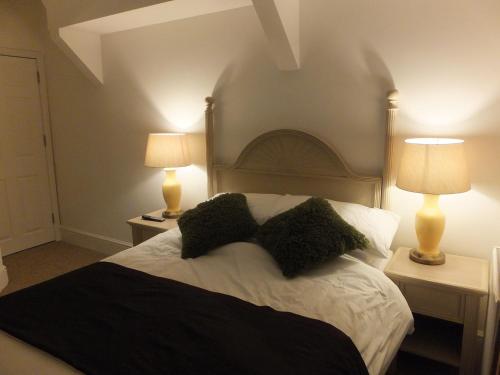 a bedroom with a large bed with two lamps at Jessamine House Hotel in Gravesend