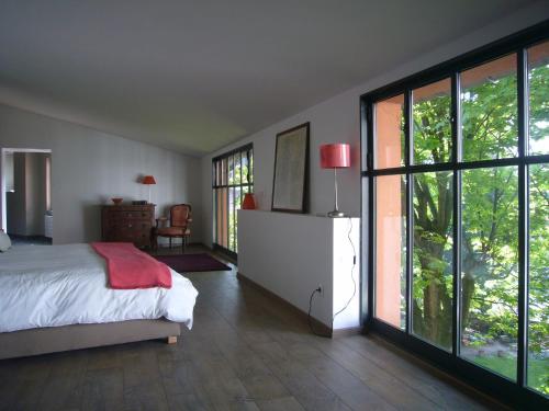 a bedroom with a bed and sliding glass doors at Le Jardin de Beauvoir in Lyon