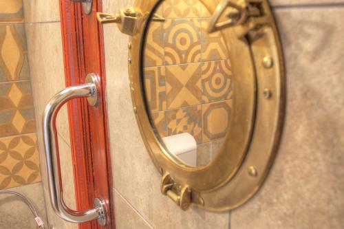 a mirror on the wall of a bathroom at Lavender Circus Hostel, Doubles & Ensuites in Budapest