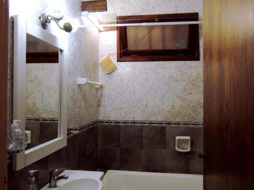 a bathroom with a sink and a bath tub at Ezenahí de la Cruz del Mar in Mar del Plata