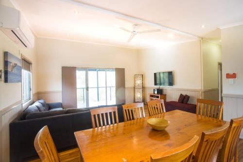a dining room with a table and a couch at Halifax Holiday Park in Nelson Bay