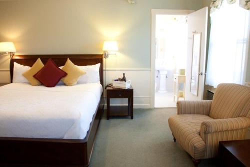 a hotel room with a bed and a chair at The Inn at Longshore in Westport