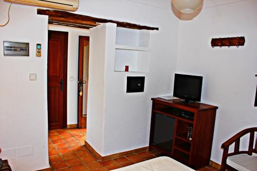 a living room with a tv on a wooden table at Agroturismo Can Fuster in Sant Joan de Labritja