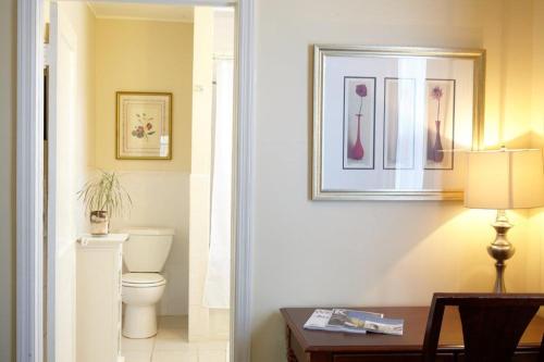 a bathroom with a toilet and a picture on the wall at The Inn at Longshore in Westport