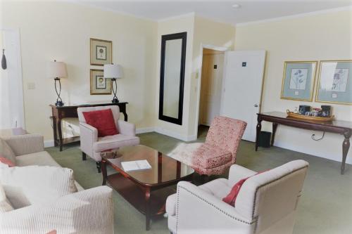 a living room with white chairs and a table at The Inn at Longshore in Westport