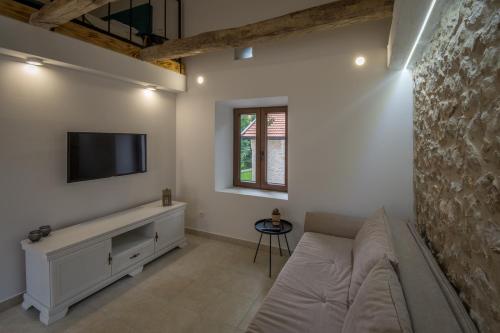 a living room with a couch and a flat screen tv at Stara kuća Estate in Ljubuški