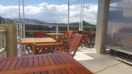 een balkon met tafels en stoelen en uitzicht op de bergen bij NK.Dalat Hotel in Da Lat