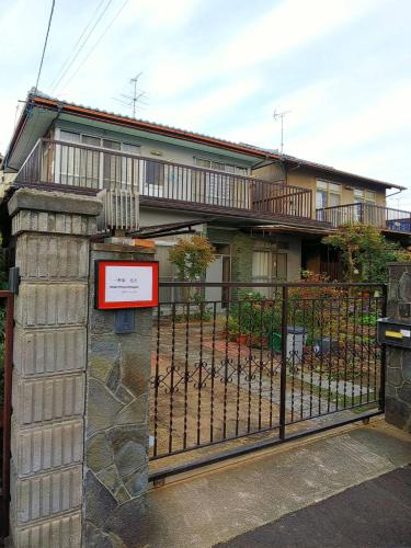 ein Haus mit einem Tor und einem Schild davor in der Unterkunft Ikkenya Kitagata in Okayama