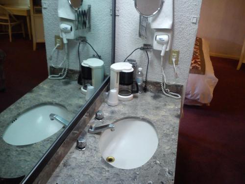 a bathroom with two sinks and two mirrors at Paraíso Express in Torreón