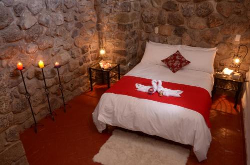 a bedroom with a bed in a stone wall at Rumi Wasi in Cusco