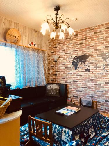 a living room with a table and a brick wall at Midtown Sakura Apartment House 102 予約者だけの空間 A space just for you in Katsuura