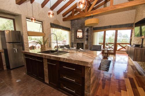 a kitchen with a large island in the middle of a room at Intiterra Apart Hotel Villas in Urubamba