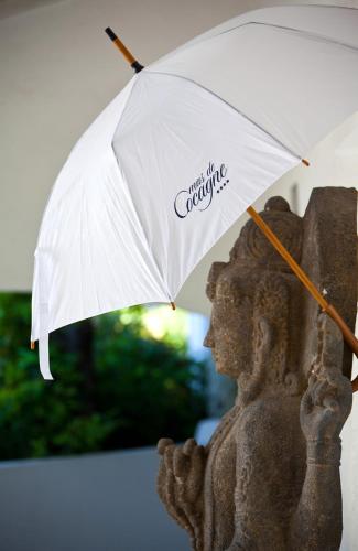 a statue holding a white umbrella next to a statue at Le Mas de Cocagne in Saintes-Maries-de-la-Mer