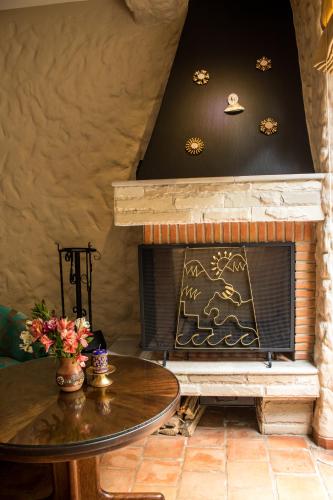 a living room with a fireplace and a table at Intiterra Apart Hotel Villas in Urubamba