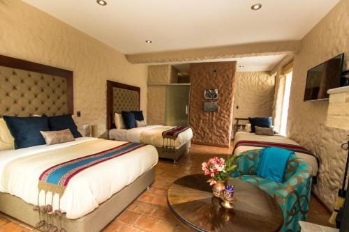 a hotel room with two beds and a table at Intiterra Apart Hotel Villas in Urubamba
