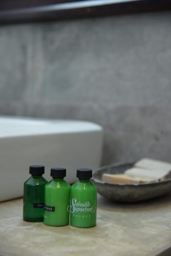 two green bottles of detergent sitting on a table at Serendib Signature Resort in Digana